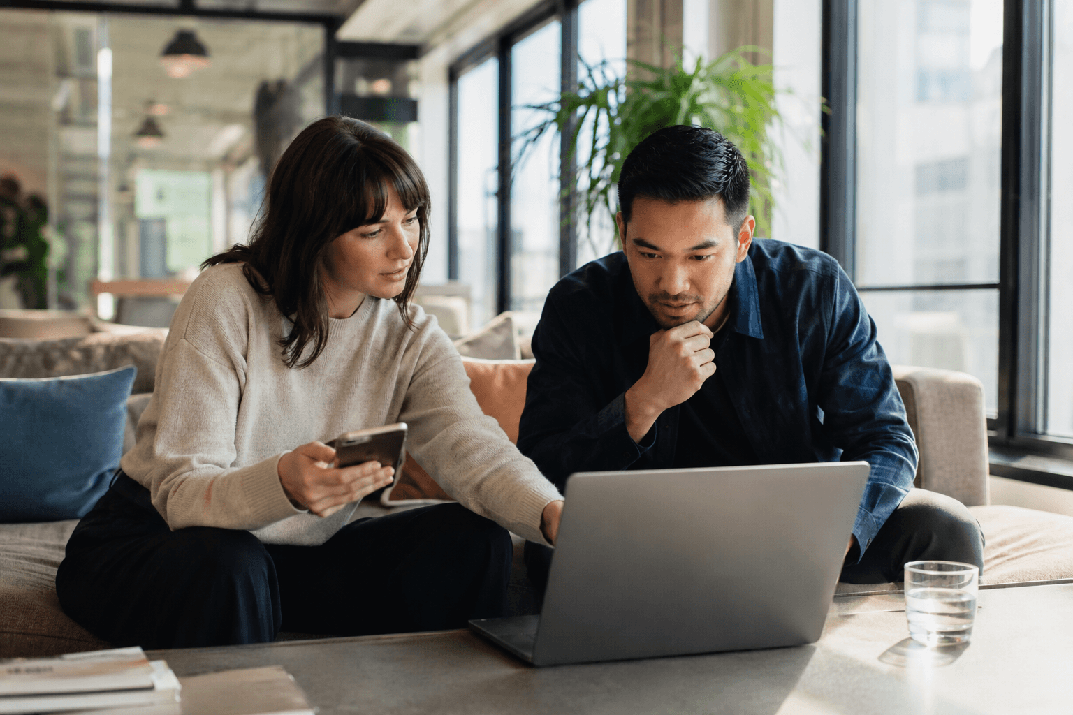 Product team reviewing a mobile experience in an office lounge
